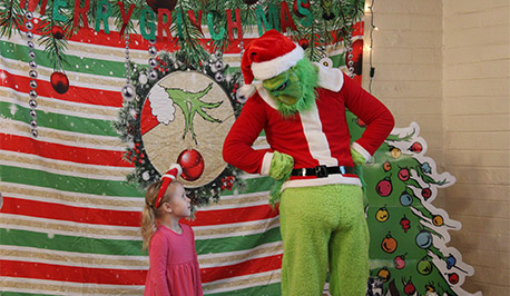 The Grinch and a little girl looking at each other