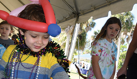 boy with a balloon hat playing a game at the Woman's Club Fair